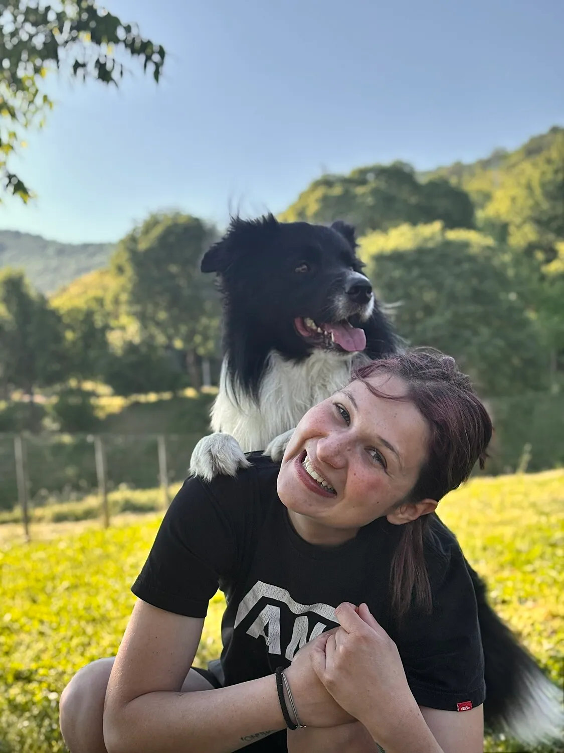 Io e Loki in un prato, lui appoggiato sulla mia schiena mentre sorridiamo
